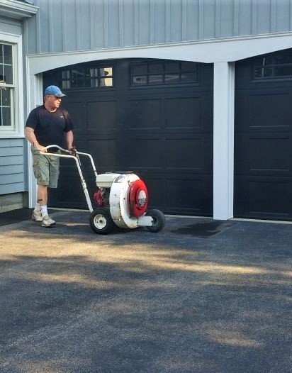 Steve Cametti cleaning a driveway with a high powered motor cleaner